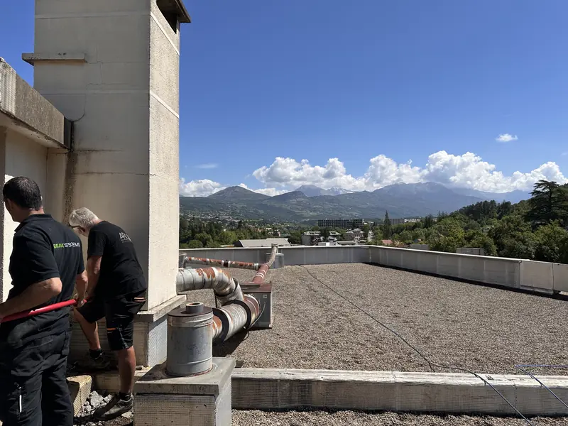 Équipe ARC Assainissement en intervention sur toiture avec vue sur les Alpes